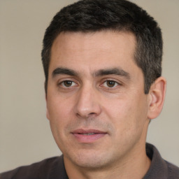Joyful white adult male with short  black hair and brown eyes
