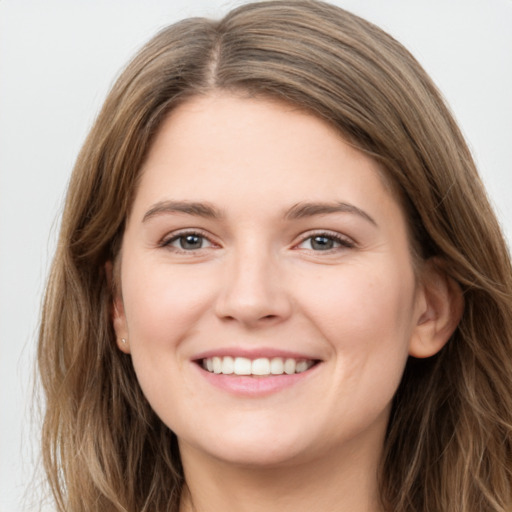 Joyful white young-adult female with long  brown hair and grey eyes