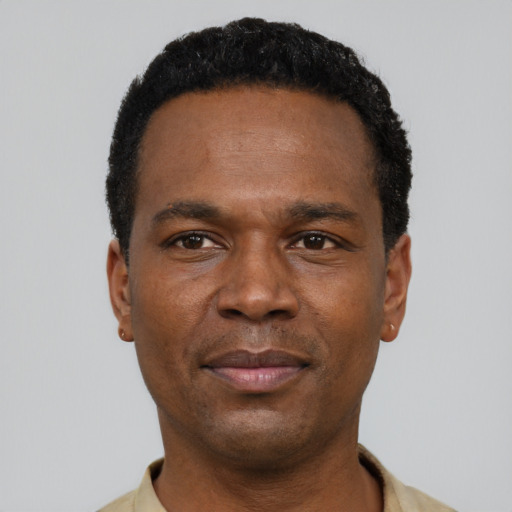Joyful black young-adult male with short  black hair and brown eyes
