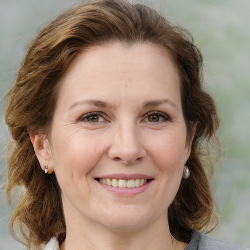 Joyful white adult female with medium  brown hair and grey eyes