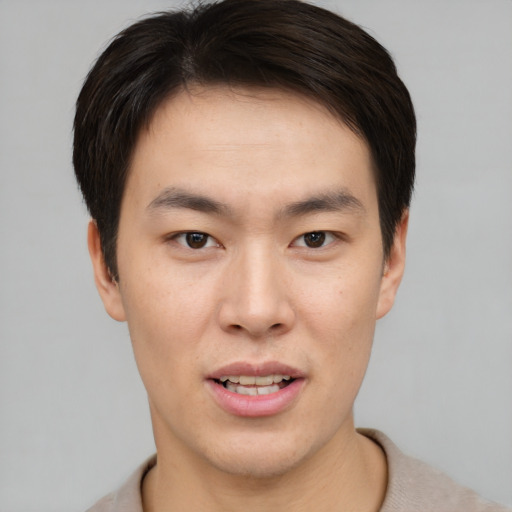 Joyful asian young-adult male with short  brown hair and brown eyes