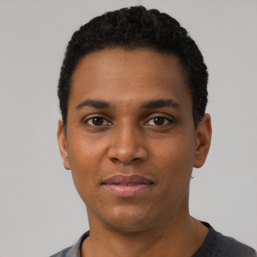 Joyful black young-adult male with short  black hair and brown eyes