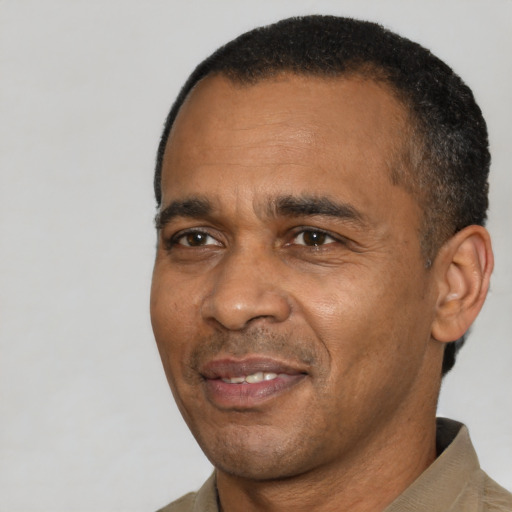 Joyful black adult male with short  black hair and brown eyes