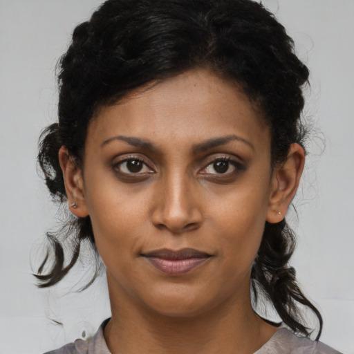 Joyful black young-adult female with medium  brown hair and brown eyes