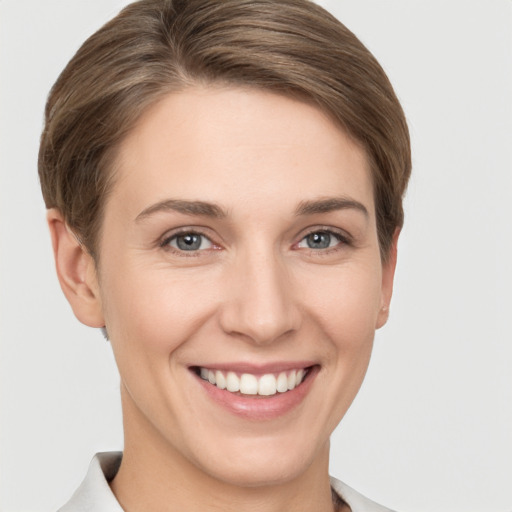 Joyful white young-adult female with short  brown hair and grey eyes