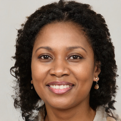 Joyful black adult female with long  brown hair and brown eyes