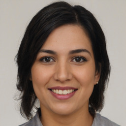 Joyful latino young-adult female with medium  brown hair and brown eyes