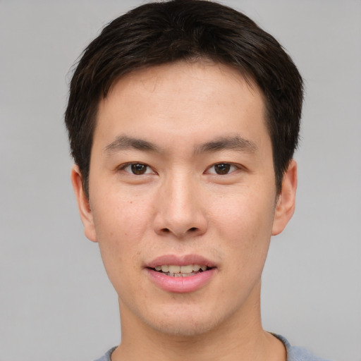 Joyful asian young-adult male with short  brown hair and brown eyes