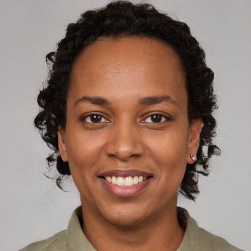 Joyful black young-adult female with short  brown hair and brown eyes