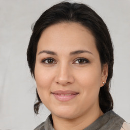 Joyful latino young-adult female with medium  brown hair and brown eyes