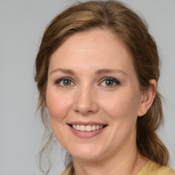 Joyful white adult female with medium  brown hair and blue eyes