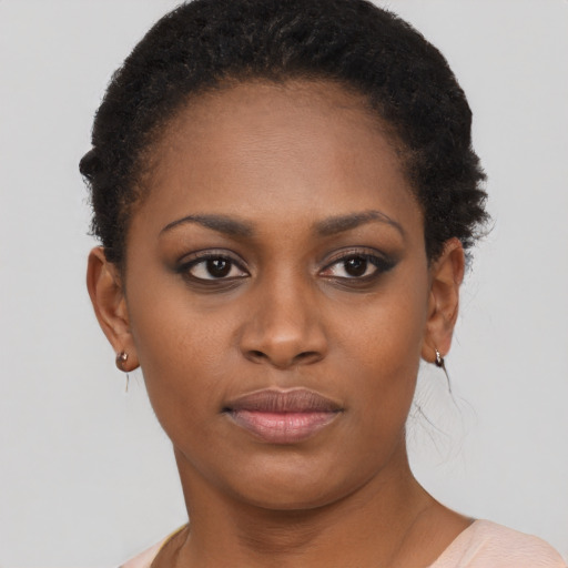 Joyful black young-adult female with short  brown hair and brown eyes