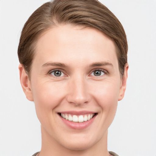 Joyful white young-adult female with short  brown hair and grey eyes