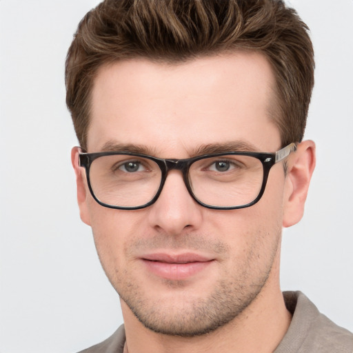 Joyful white young-adult male with short  brown hair and grey eyes