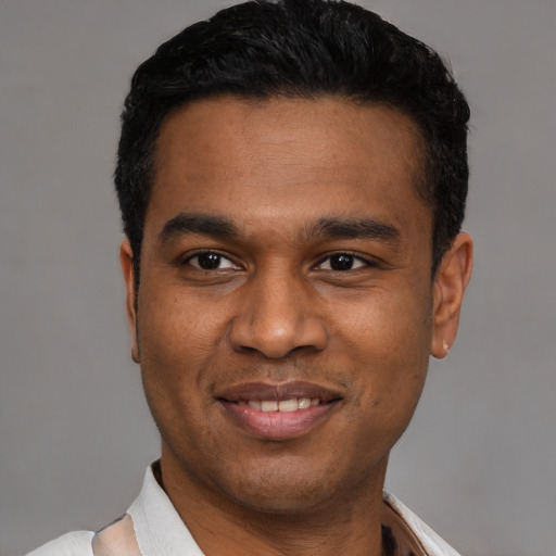 Joyful latino young-adult male with short  black hair and brown eyes
