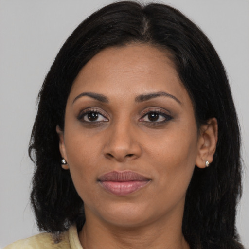Joyful black young-adult female with long  brown hair and brown eyes