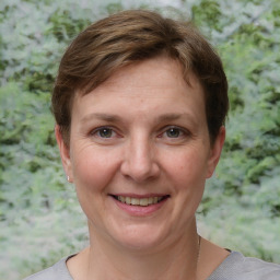 Joyful white adult female with short  brown hair and grey eyes