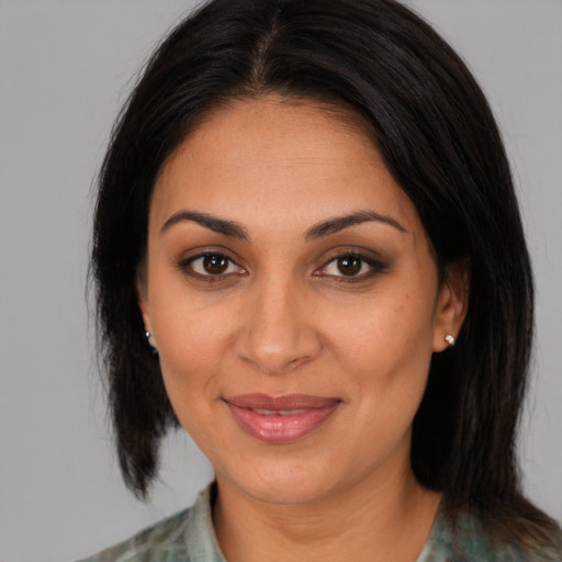 Joyful latino adult female with medium  brown hair and brown eyes