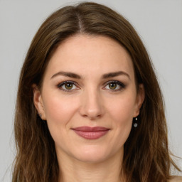 Joyful white young-adult female with long  brown hair and green eyes