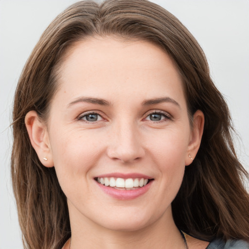 Joyful white young-adult female with long  brown hair and blue eyes