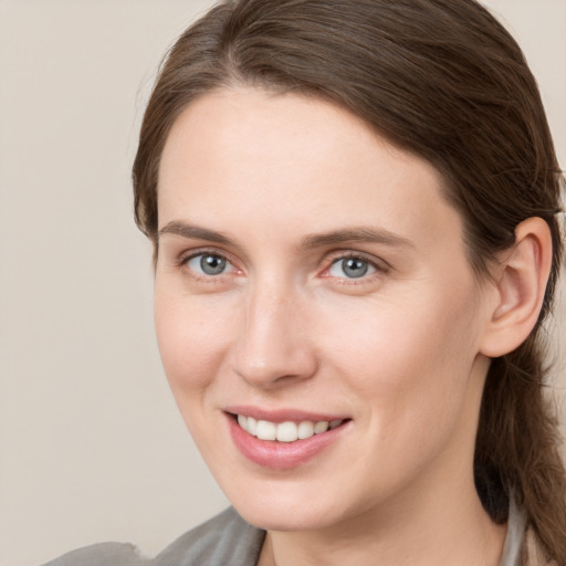 Joyful white young-adult female with medium  brown hair and grey eyes