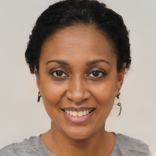 Joyful black adult female with short  black hair and brown eyes