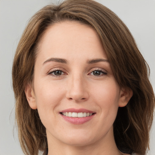 Joyful white young-adult female with medium  brown hair and green eyes