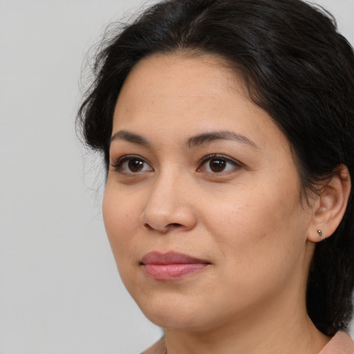 Joyful latino young-adult female with medium  brown hair and brown eyes