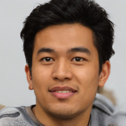 Joyful asian young-adult male with short  black hair and brown eyes