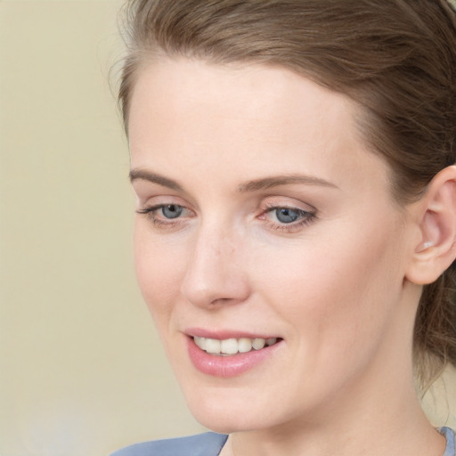 Joyful white young-adult female with medium  brown hair and blue eyes