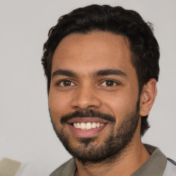 Joyful latino young-adult male with short  black hair and brown eyes