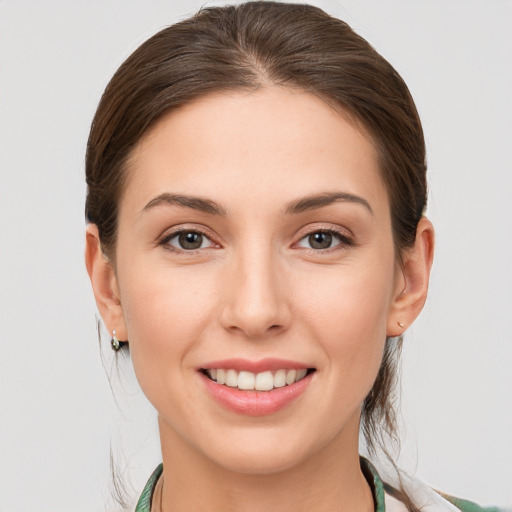 Joyful white young-adult female with medium  brown hair and grey eyes