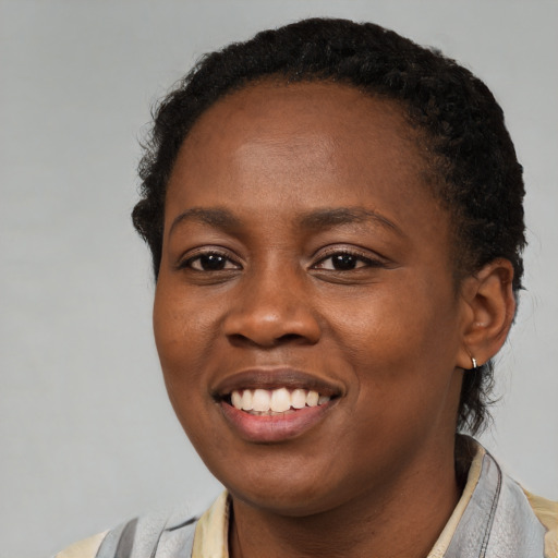 Joyful black young-adult female with short  brown hair and brown eyes