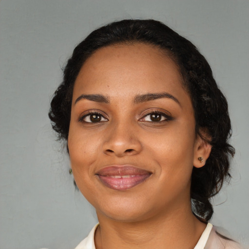 Joyful black adult female with medium  black hair and brown eyes