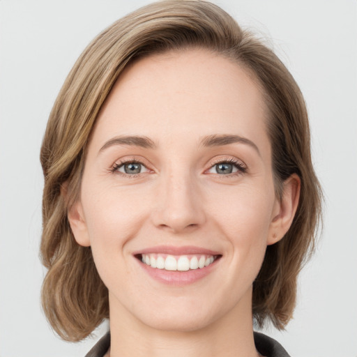 Joyful white young-adult female with medium  brown hair and blue eyes