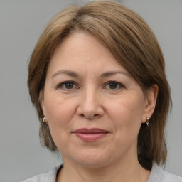 Joyful white adult female with medium  brown hair and grey eyes