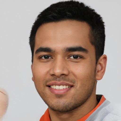 Joyful latino young-adult male with short  black hair and brown eyes