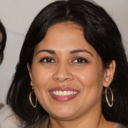 Joyful latino adult female with medium  brown hair and brown eyes