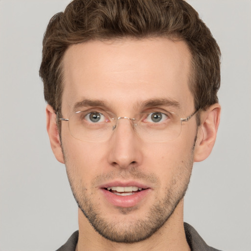 Joyful white young-adult male with short  brown hair and grey eyes