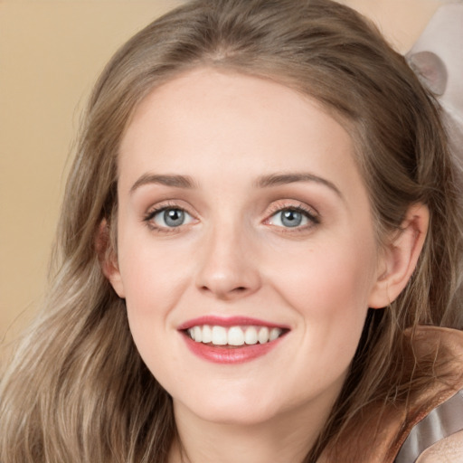 Joyful white young-adult female with long  brown hair and blue eyes