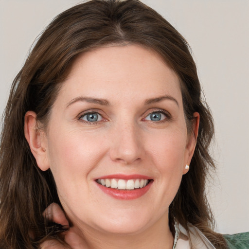 Joyful white young-adult female with long  brown hair and blue eyes