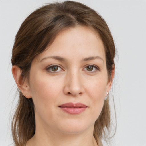 Joyful white young-adult female with medium  brown hair and grey eyes