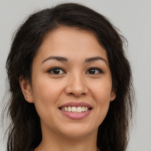 Joyful white young-adult female with long  brown hair and brown eyes