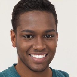 Joyful black young-adult male with short  brown hair and brown eyes