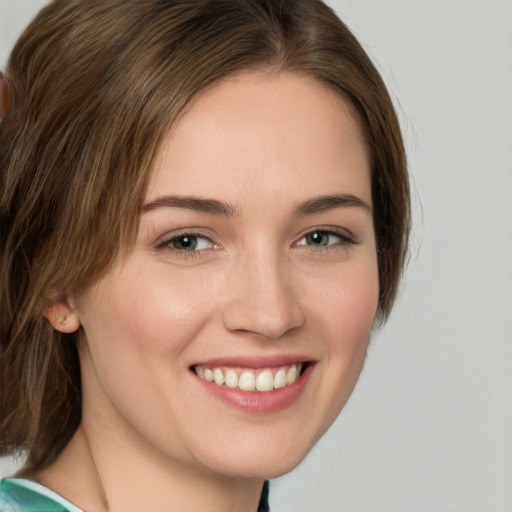 Joyful white young-adult female with medium  brown hair and green eyes