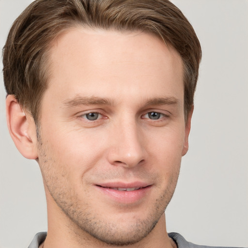 Joyful white young-adult male with short  brown hair and grey eyes