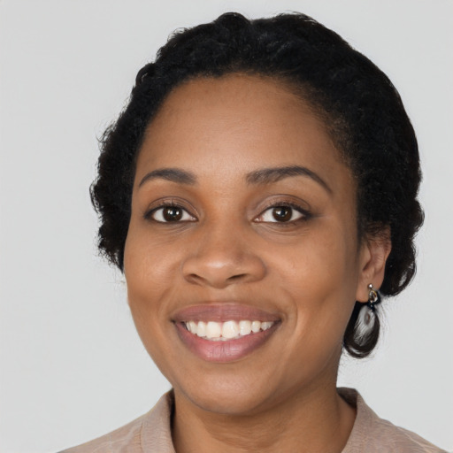 Joyful black young-adult female with short  black hair and brown eyes