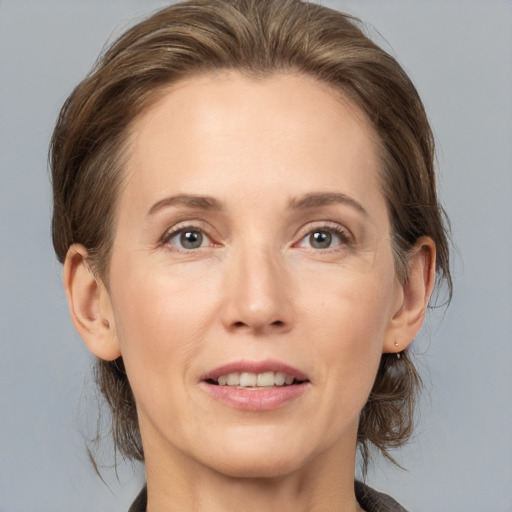 Joyful white adult female with medium  brown hair and grey eyes