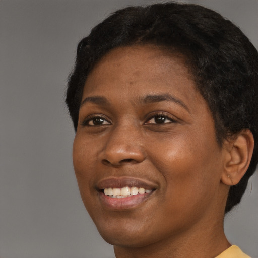 Joyful black young-adult female with short  brown hair and brown eyes
