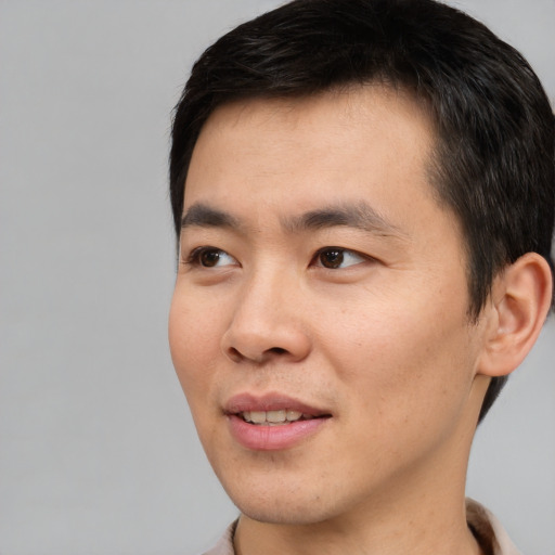 Joyful white young-adult male with short  black hair and brown eyes